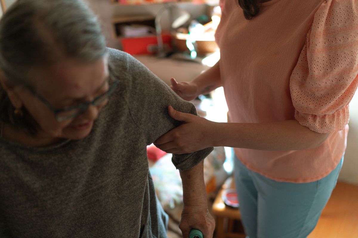 Intervenante accompagnant une personne âgée dans ses déplacements à domicile